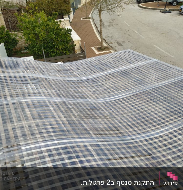 גג פלסטיק שקוף עם קורות עץ מתחת